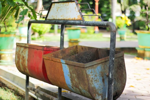 Rusty Dual Trash Bins in a Park with Greenery in Background photo