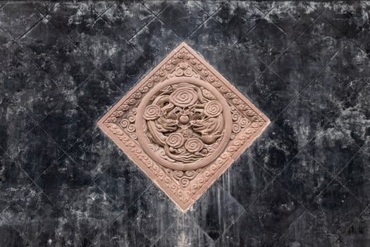 Black tiles floor with brown stone carving of dragons photo