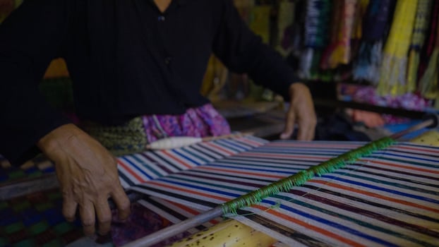 Colorful of Kain Tenun, an Indonesian traditional hand woven fabric from West Nusa Tenggara or Lombok, hanging for sale in Sade village as souvenirs photo