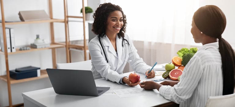 Happy nutritionist black woman giving consultation to patient with healthy fruit and vegetable, nutrition and diet concept photo