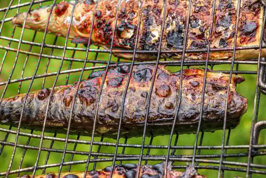 The process of cooking mackerel fish in a marinade on the grill. Fried fish is ready. photo