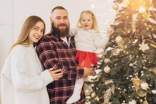 Happy family decorating christmas tree together at home photo