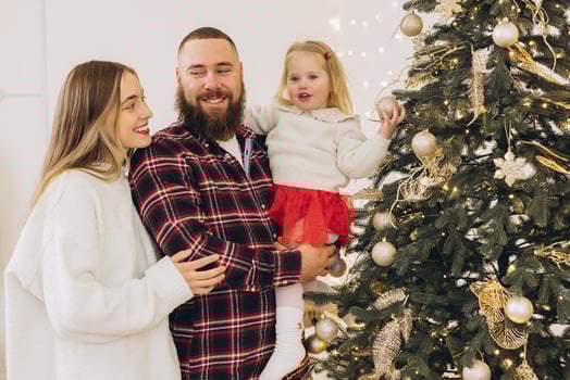 Family decorating christmas tree together at home photo