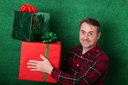 smiling man with a large gift in his hands on a green background. holiday. New Year. Valentine's Day photo