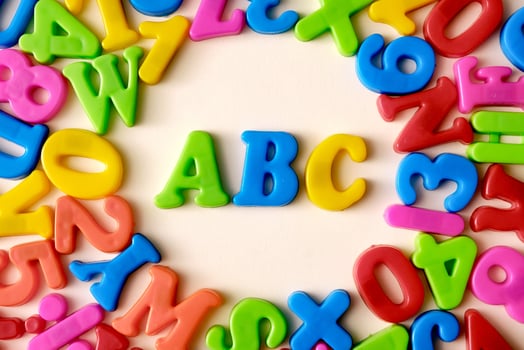 Letters and symbols of the alphabet on a yellow background. Back cheek concept. ABC photo