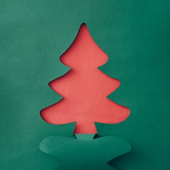 Colorful green Christmas tree paper cutout over sparkling white snow with copyspace for your holiday message or greeting in a creative handmade card photo
