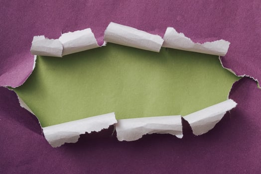 Ripped or torn purple paper frame with green copy space photo