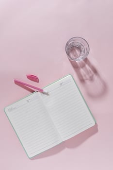 Pink feminine office workspace still life with open journal photo