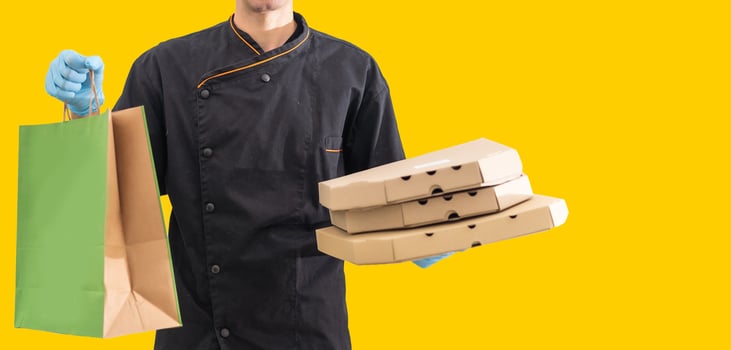 Young handsome delivery man holding paper bag with takeaway food happy with big smile. photo