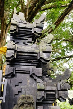 Ancient black stucco decorated on arched entrance gate and facade in a Hindu temple of Hinduism on Bali Island of Indonesia. Travel destination for culture and religion of Asian photo
