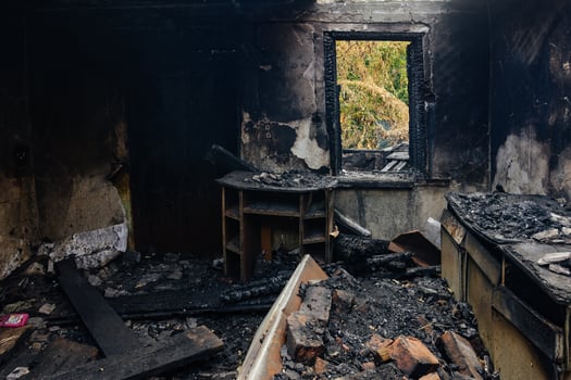 Fire aftermath. Burnt wooden house interior with remnant of furniture photo