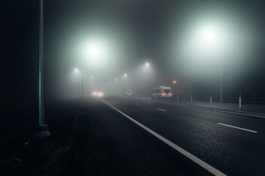 Foggy night road illuminated by street lights photo