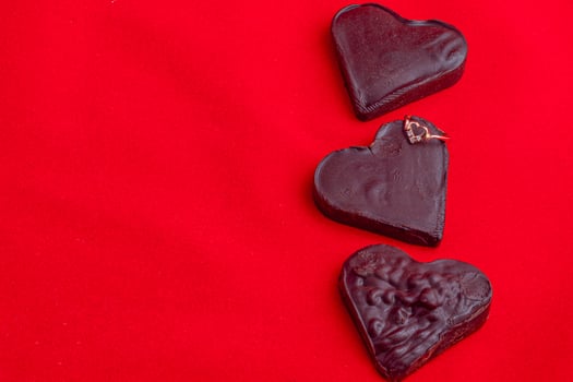 Valentine's Day celebration composition, chocolate hearts on a red background photo