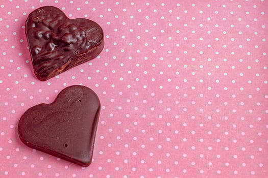 Composition of chocolate hearts on a pink background for Valentine's Day photo