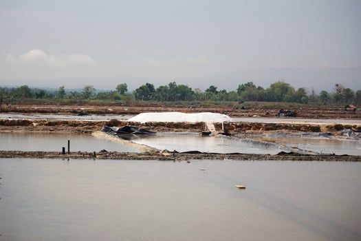 Salt Piles and Evaporation Ponds in Rural Landscape with Distant Hills View photo