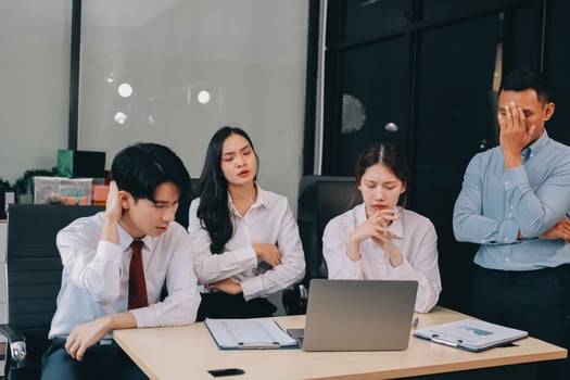 Frustrated upset multiracial business team people sad with bad work result in report disappointed in corporate bankruptcy failure crisis worried of paperwork problem sit at table at office meeting photo