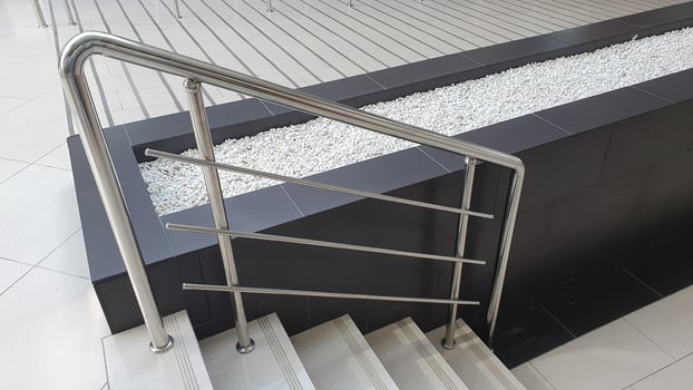 Metallic railing along the staircase. Railing protection from falling down on the staircase. Elderly and disabled people care. photo