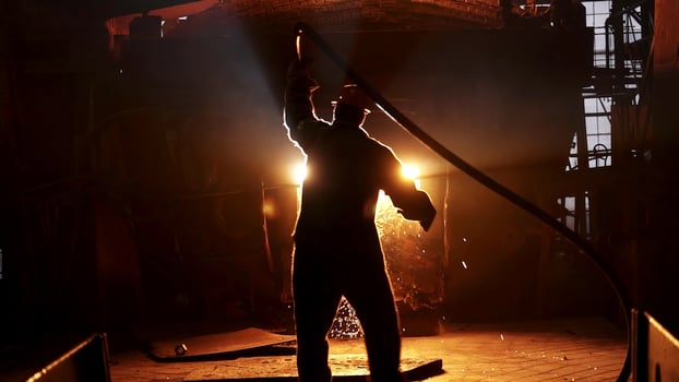 An Industrial Worker Skillfully Handling Molten Metal in a Vibrant and Bright Glow. Stock Clip photo