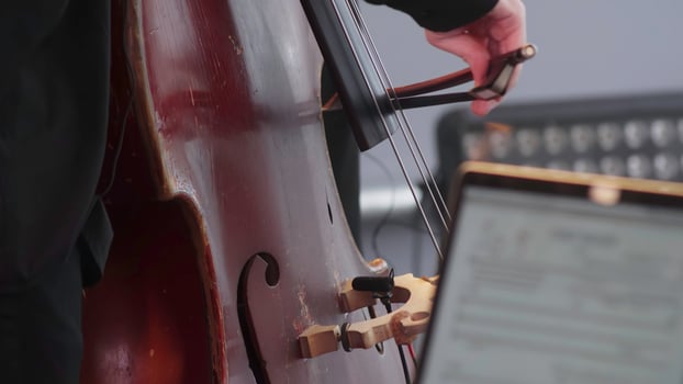 A talented musician skillfully playing the cello during an engaging performance on stage. Clip photo