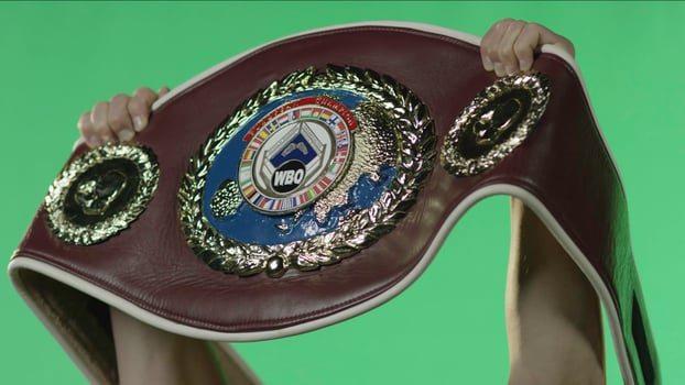 An individual proudly displays a boxing championship belt photo