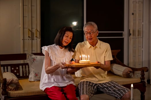 Senior asian couple is happily celebrating birthday together at their home for love, relationship, bonding, longevity and marriage concept photo