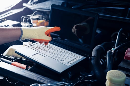 Car inspection service using a modern computer system. and a modern mechanic in the garage Auto mechanics use computer software to check two engines are running and repair them. photo
