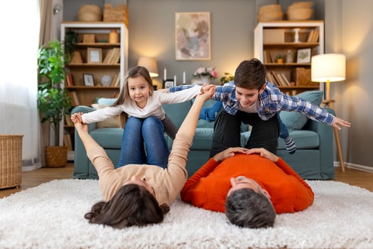 A family is playing on the floor in a living room photo