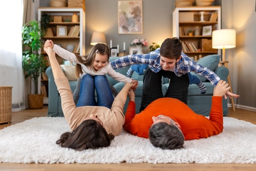 A family is playing on a rug in their living room photo