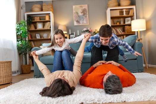 A family is playing on a rug in their living room photo