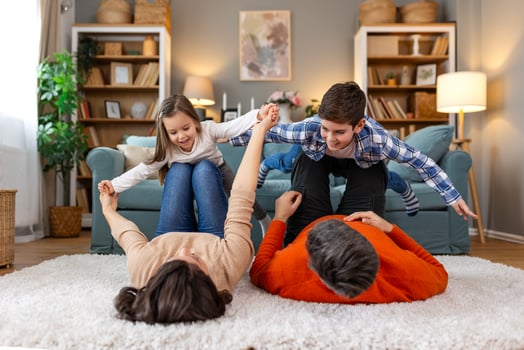 A family is playing on the floor in a living room photo