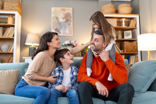 A family sitting on a couch in a living room photo