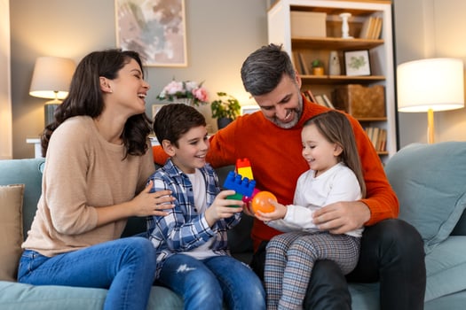 A family sitting on a couch playing with toys photo