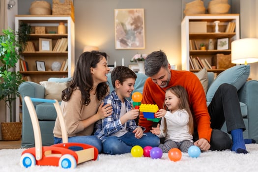 A family playing with toys in their living room photo