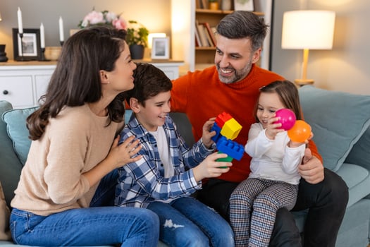 A family playing with toys on a couch photo