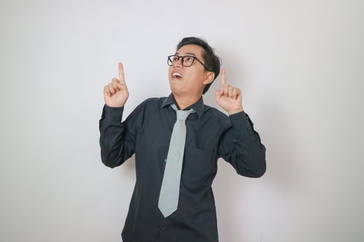young asian men wearing black shirt pointing up copy space photo