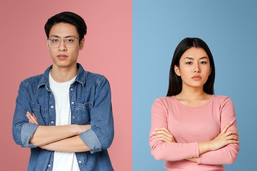 Relationships crisis during isolation. Upset young asian man and woman with crossed arms posing over grey background photo