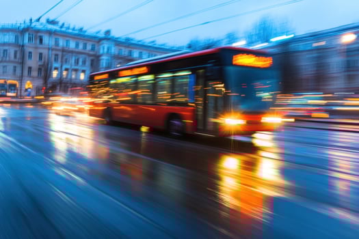 Blurred motion of a red bus driving in the city during dusk. photo