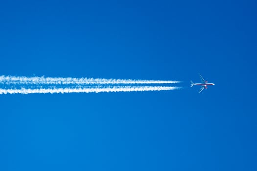 Skyward Journey A Lone Airplane Traces the Canvas of Clouds with Ethereal Contrails, Painting Dreams Across the Vast Blue Horizon. photo