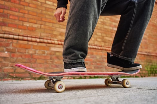 Skateboarder doing trick at urban street. Close up of skater wearing baggy jeans balancing on skateboard. Concept of youth subculture photo