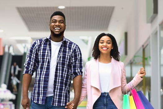 Shopping Concept. Happy Black Couple Walking In Mall Carrying Colorful Shopper Bags, Free Space photo