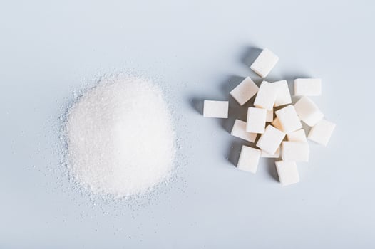 Alternative between lump sugar and granulated sugar on a blue background top view photo