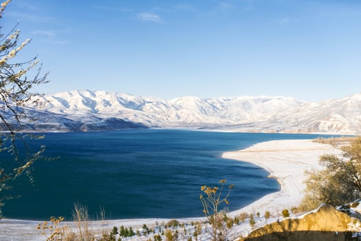 Amazing beautiful winter landscape of Charvak reservoir in Uzbekistan in winter with blue water in it, surrounded by the Tien Shan mountain system photo