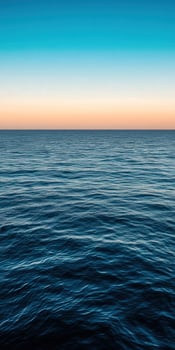 Calm ocean waves reflecting colorful sky at sunset over the horizon photo
