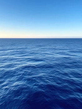 Calm blue ocean under clear sky at sunset during summer photo