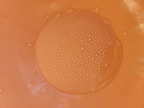 Orange plastic background with water droplets photo