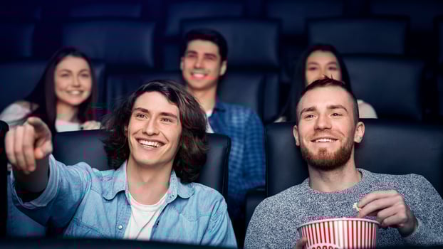 Weekend activity. Smiling young friends on movie night in cinema photo