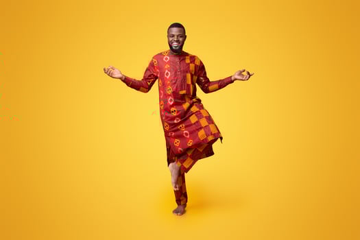 Happy african man standing on one leg, meditating over yellow background photo