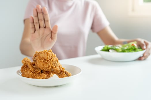 Beauty slim female body confuse fried chicken. Woman in restaurant achieves weight loss goal for healthy life, crazy about thinness, thin waist, nutritionist. Diet, body shape. photo