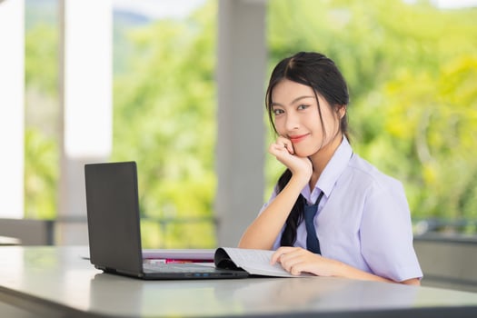 portrait happy school uniform teen girl using laptop computer to do homework learning education in school campus, self education technology concept. photo