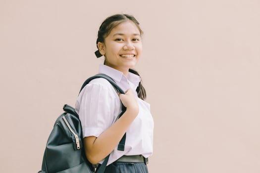 Portrait Thai Asian School girl teen cute student in uniform standing happy smile with shoulder bag isolated space for text. photo